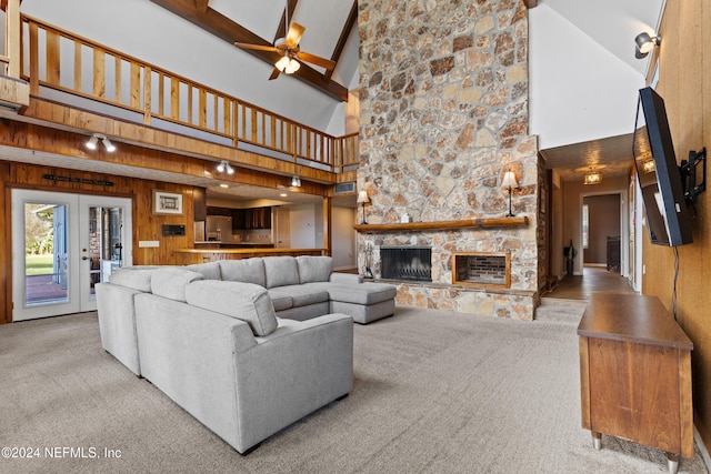 living room with high vaulted ceiling, beam ceiling, light carpet, and a fireplace