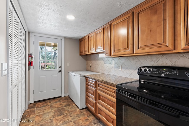 kitchen with decorative backsplash, a textured ceiling, black electric range, and light stone counters