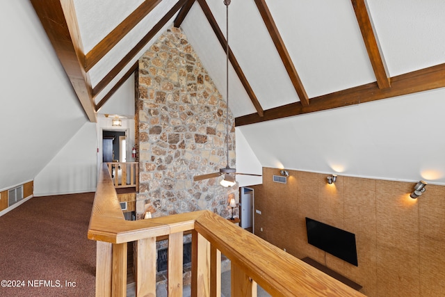 stairs with beam ceiling, high vaulted ceiling, and carpet