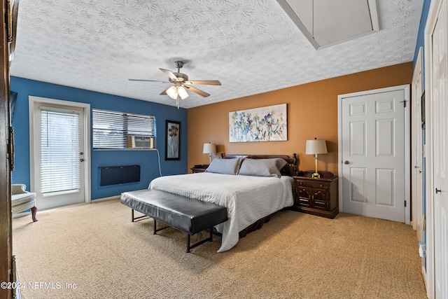 bedroom with a textured ceiling, light colored carpet, and ceiling fan