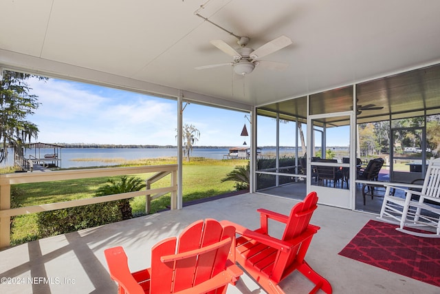 sunroom / solarium with a healthy amount of sunlight, a water view, and ceiling fan