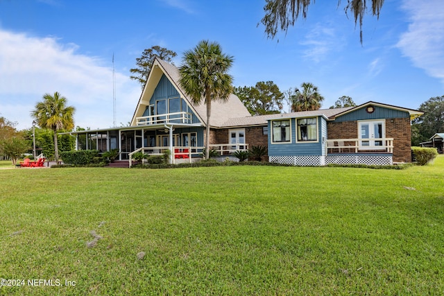 rear view of house with a sunroom and a lawn