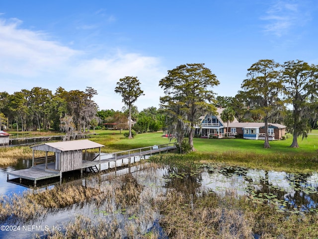 view of dock featuring a water view and a yard