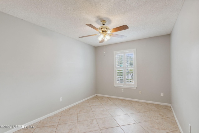 tiled spare room with a textured ceiling and ceiling fan