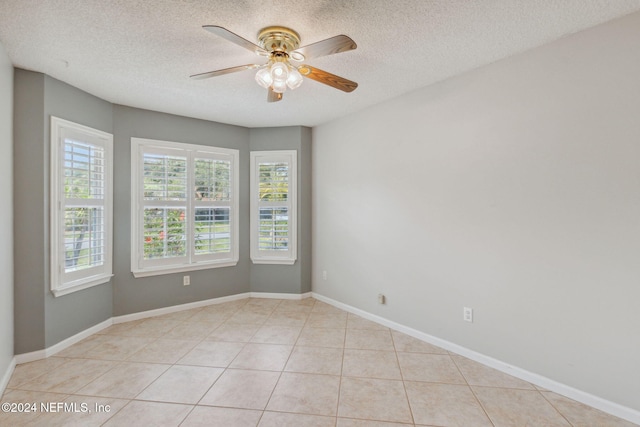 unfurnished room with ceiling fan, a textured ceiling, and light tile patterned floors