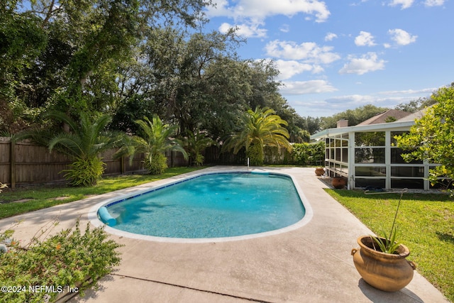 view of swimming pool with a yard and a sunroom