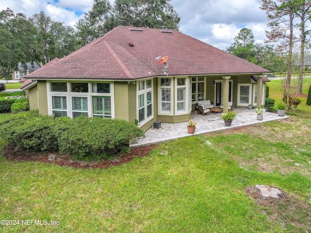 back of property featuring a lawn and a patio