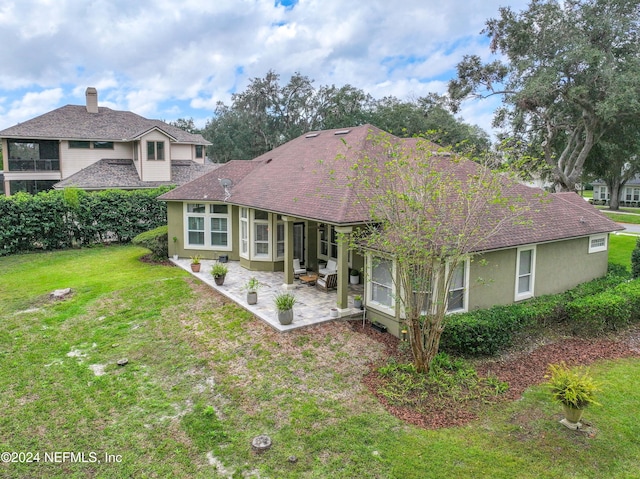 back of house featuring a lawn and a patio area