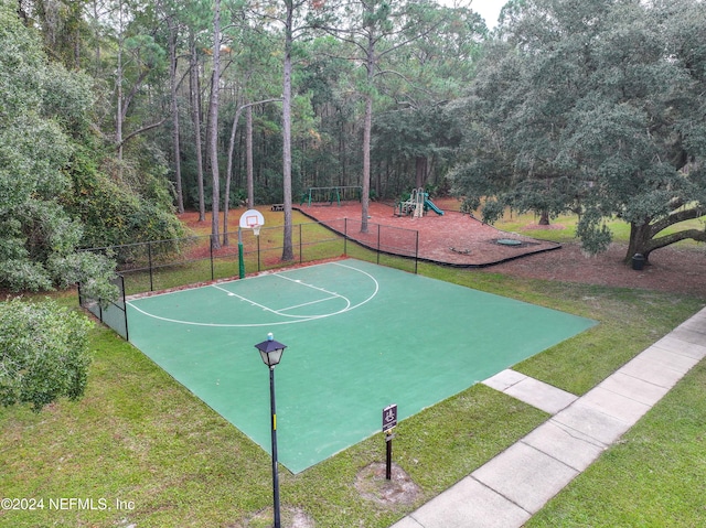 view of basketball court featuring a playground and a yard