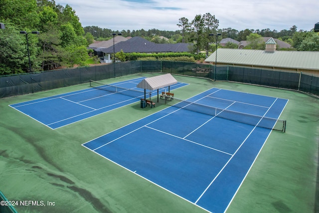 view of tennis court with basketball hoop