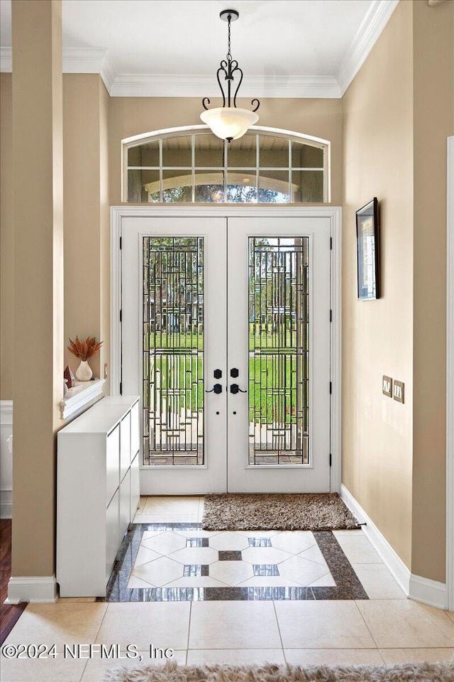 tiled entrance foyer featuring french doors and ornamental molding