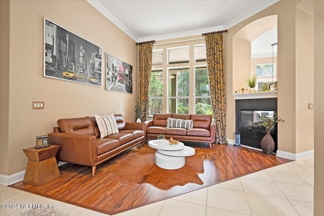 living room featuring a multi sided fireplace, wood-type flooring, and ornamental molding