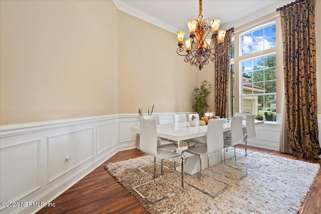 dining room featuring hardwood / wood-style flooring, ornamental molding, a healthy amount of sunlight, and an inviting chandelier