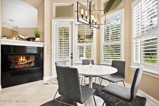 dining space featuring light tile patterned floors, an inviting chandelier, vaulted ceiling, and a wealth of natural light