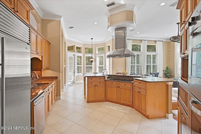 kitchen with ornamental molding, stainless steel built in refrigerator, island range hood, pendant lighting, and dishwasher