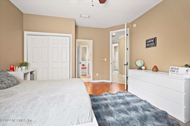 bedroom with hardwood / wood-style flooring, a closet, and ceiling fan