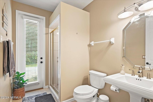 bathroom featuring tile patterned floors, toilet, walk in shower, and sink