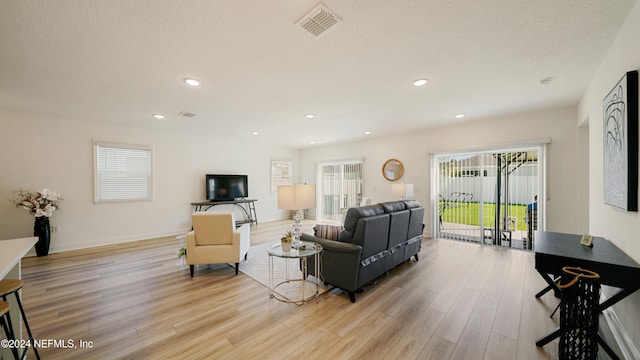 living room featuring a textured ceiling and light hardwood / wood-style flooring