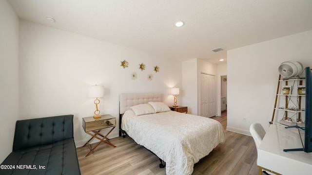 bedroom featuring hardwood / wood-style floors and a closet