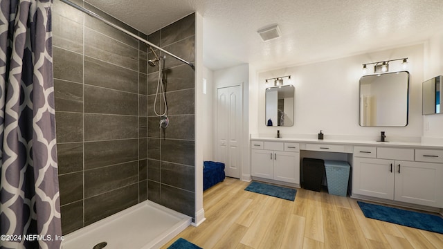 bathroom featuring a textured ceiling, vanity, hardwood / wood-style flooring, and a shower with curtain