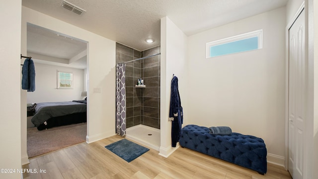 bathroom with hardwood / wood-style floors, a healthy amount of sunlight, and curtained shower