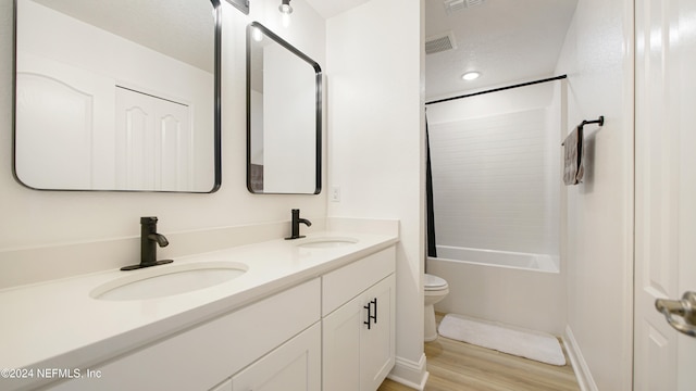 full bathroom with washtub / shower combination, wood-type flooring, vanity, and toilet