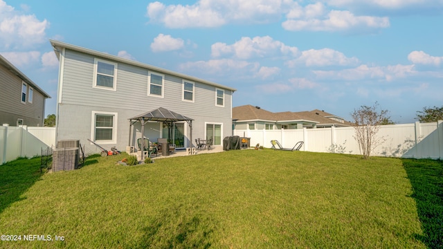 rear view of property featuring a yard, a gazebo, and a patio area