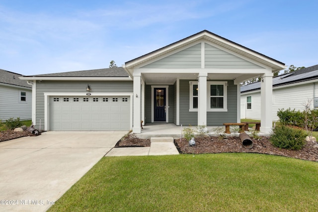 view of front of home with a front yard, a garage, and covered porch