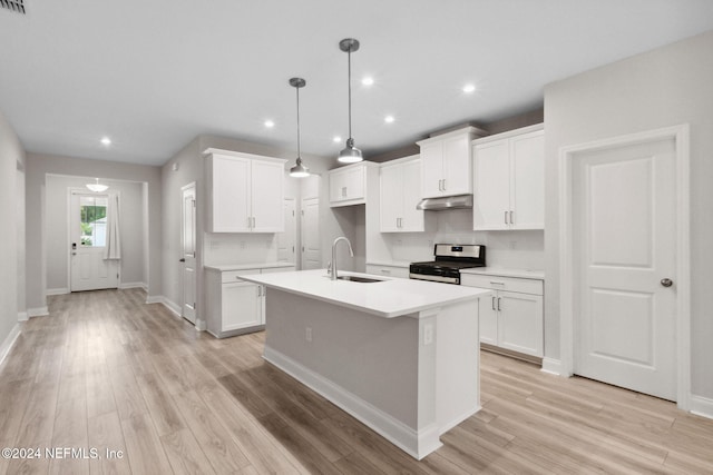 kitchen with white cabinets, gas stove, sink, and a kitchen island with sink