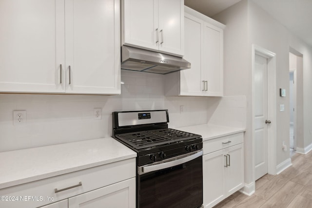 kitchen featuring backsplash, light hardwood / wood-style flooring, white cabinetry, and stainless steel gas range oven