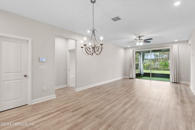 unfurnished room with ceiling fan with notable chandelier and light hardwood / wood-style flooring