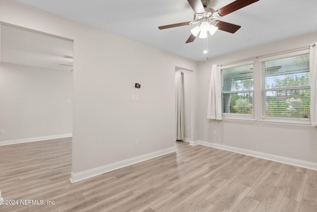 empty room with ceiling fan and light hardwood / wood-style floors