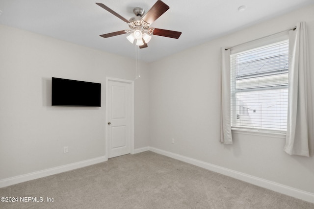 carpeted spare room with ceiling fan