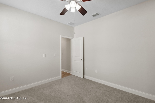 empty room with ceiling fan and carpet