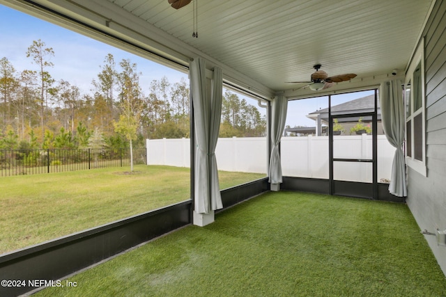 unfurnished sunroom featuring ceiling fan