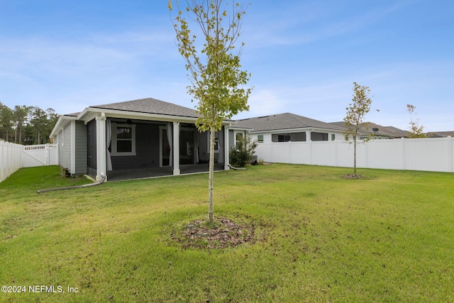 rear view of house featuring a yard