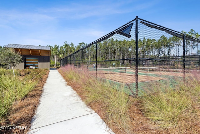 view of home's community featuring tennis court