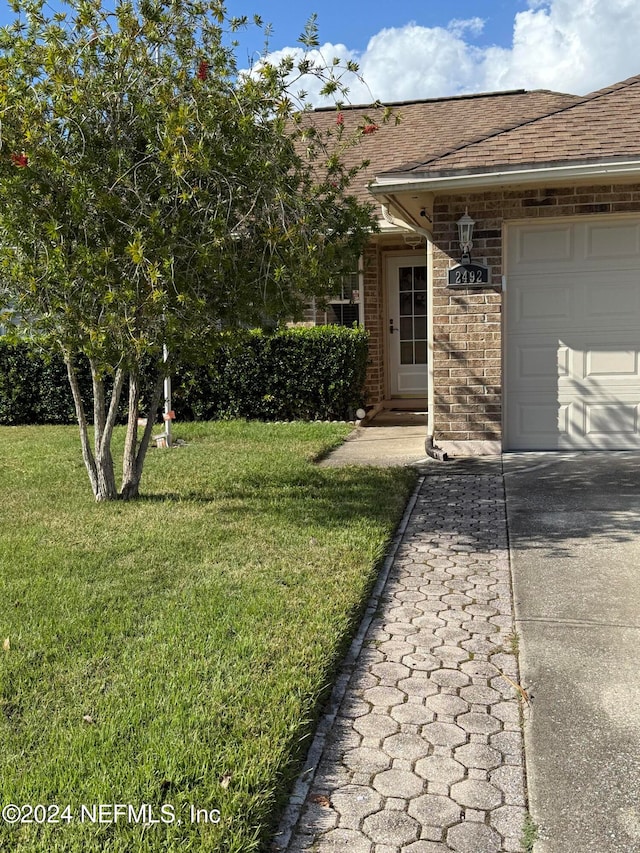 entrance to property with a garage and a yard