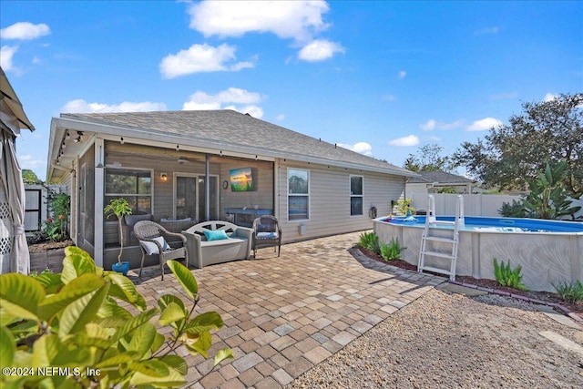 back of house featuring a sunroom, a fenced in pool, and a patio