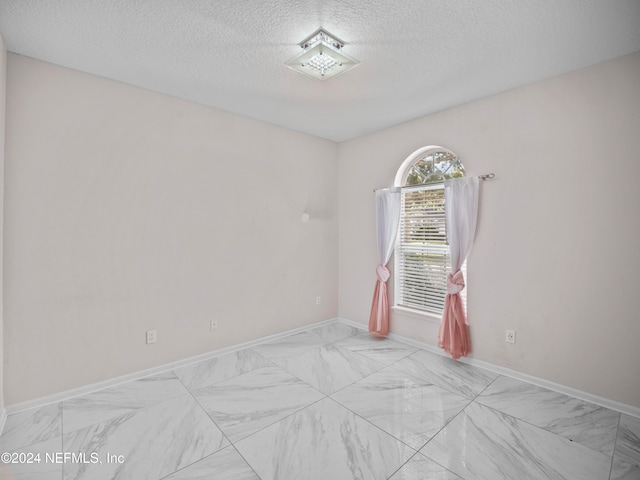 spare room featuring a textured ceiling