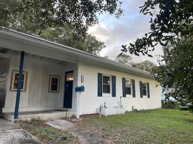 ranch-style house featuring a front lawn and a porch