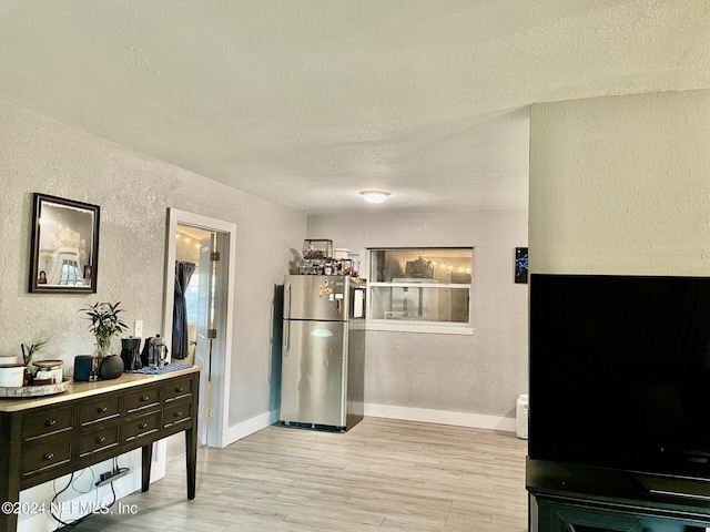 interior space featuring a textured ceiling and light hardwood / wood-style flooring