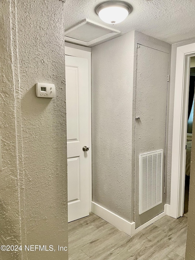 1425 Domas Dr, Jacksonville, FL 32211 - hallway featuring wood finished floors, a textured ceiling, a textured wall, and baseboards