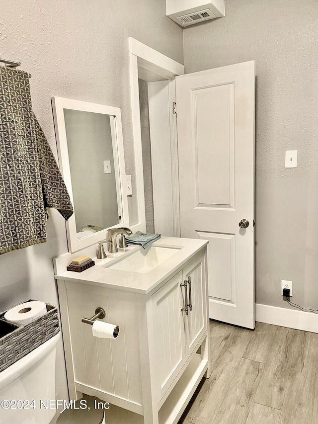 bathroom featuring hardwood / wood-style floors, vanity, and toilet