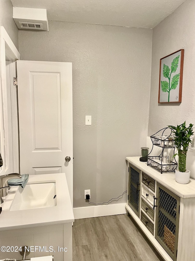 laundry room featuring hardwood / wood-style flooring and sink