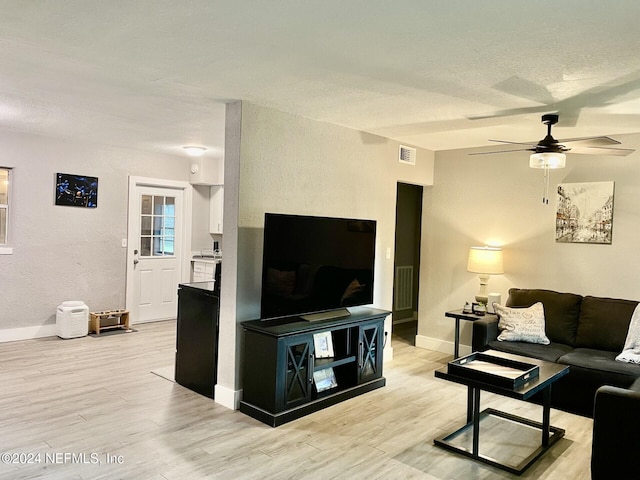 living room with ceiling fan and light hardwood / wood-style flooring