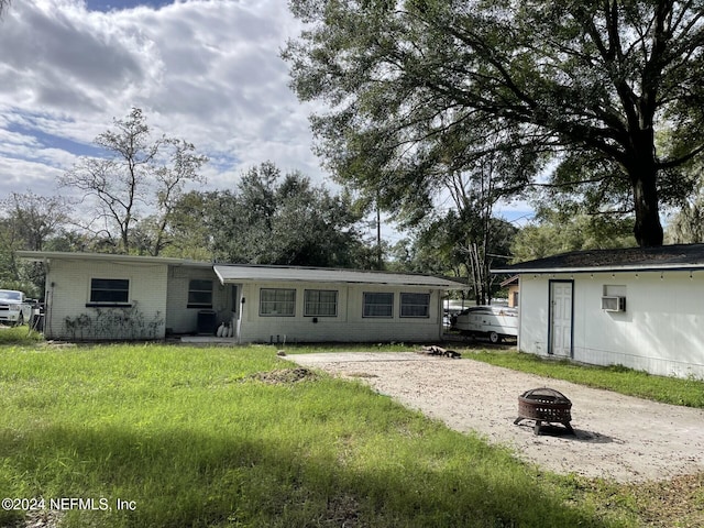 1425 Domas Dr, Jacksonville, FL 32211 - back of house with a fire pit, a wall mounted AC, and a yard