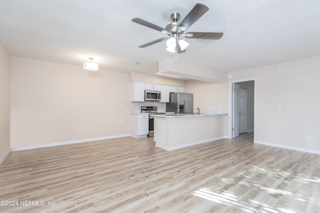 kitchen with appliances with stainless steel finishes, sink, light hardwood / wood-style floors, white cabinets, and ceiling fan