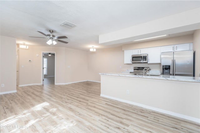 kitchen featuring white cabinets, light wood-type flooring, and appliances with stainless steel finishes