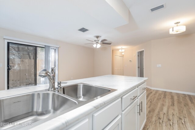 kitchen featuring white cabinetry, sink, ceiling fan, and light hardwood / wood-style floors